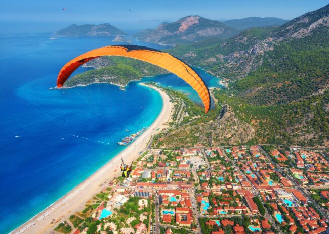 paraglider-tandem-flying-over-the-sea-with-blue-wa-2024-11-28-03-28-46-utc